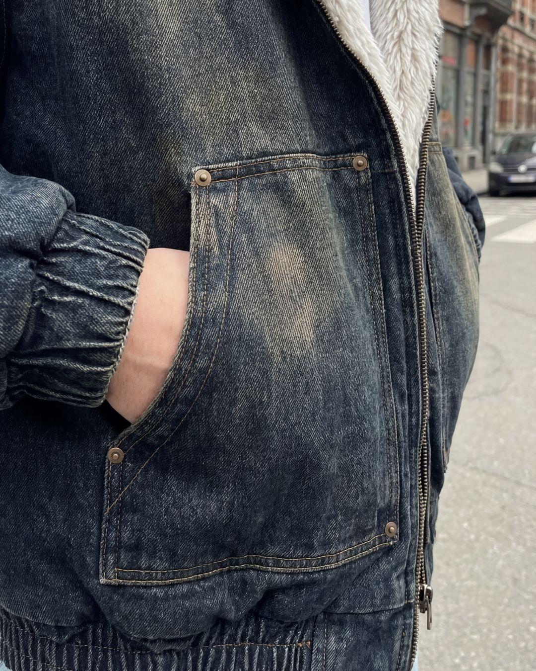 Washed denim jacket side pocket detail — hand in pocket