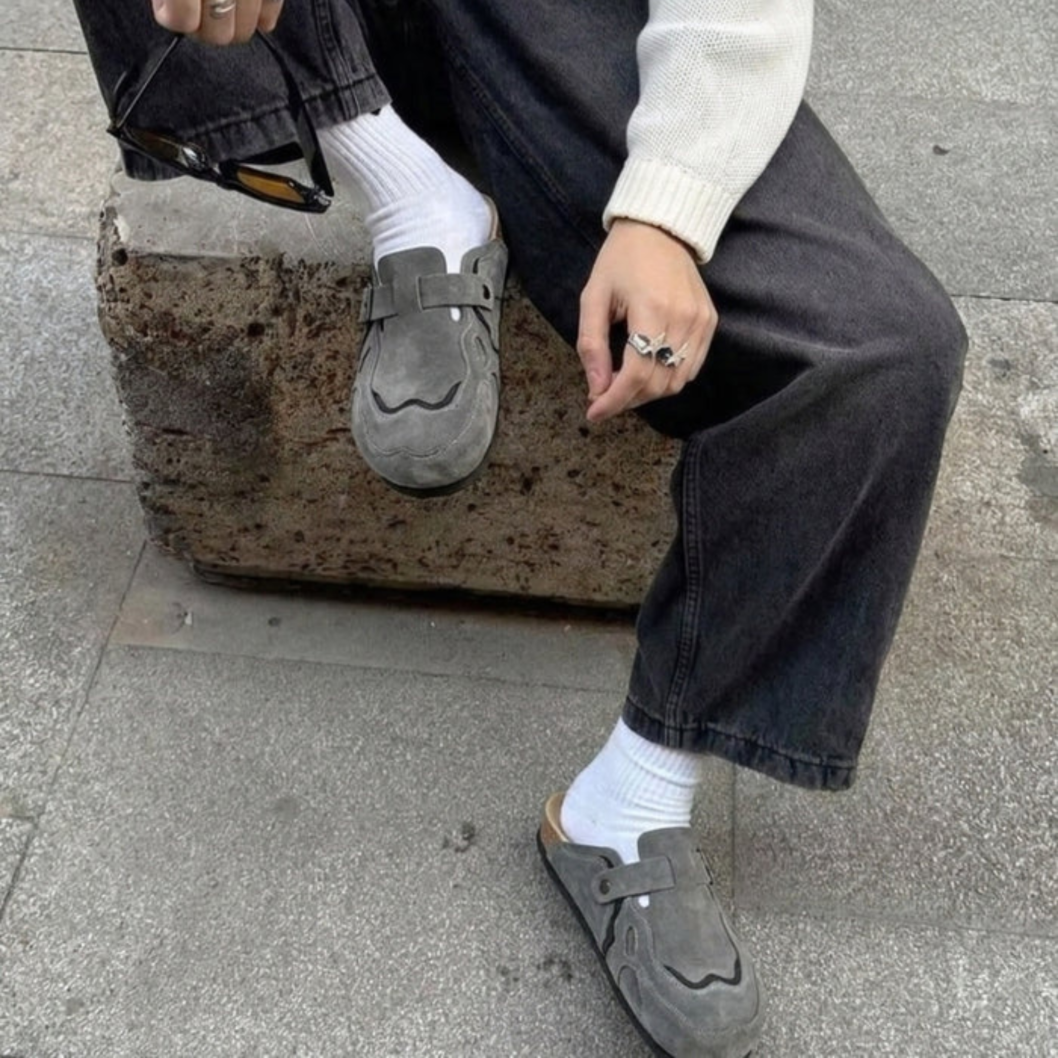 Model wearing Wavey Clogs in grey with white socks and black jeans